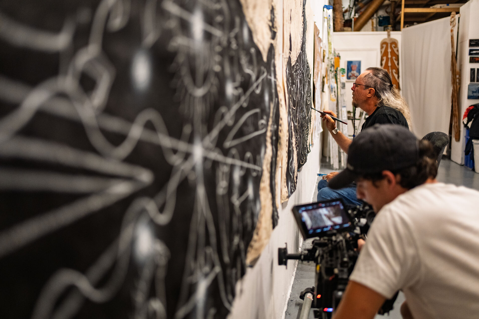 Filming artist at work on large-scale painting